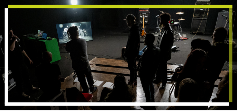 On set on a sound stage. A film crew watching a replay on a monitor.