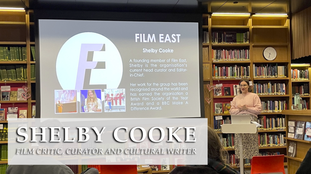 Shelby Cooke Film Critic, Curator and Cultural Writer A person stood in front of a bookcase presenting to a seated crowd.