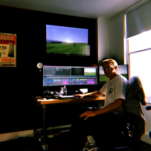 A photo of Luke Everest sat at a computer with editing software on it
