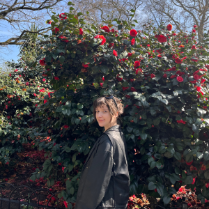 A photo of Laura Zvarikova in front of a rose bush