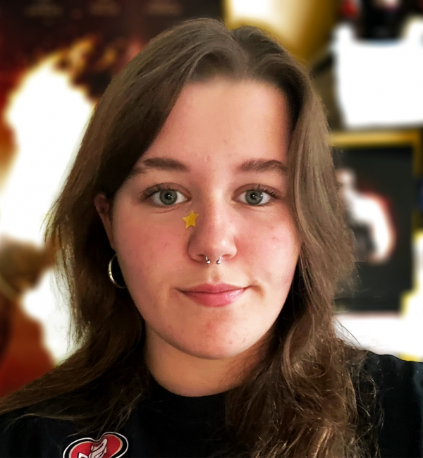 A young person with long wavy brown hair and dark eyes.